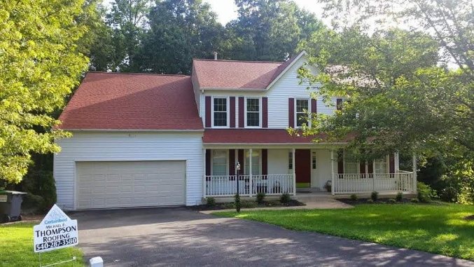 After roof replacement showing the completed red shingle roof